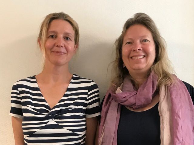 To smilende voksne damer mot hvit bakgrunn