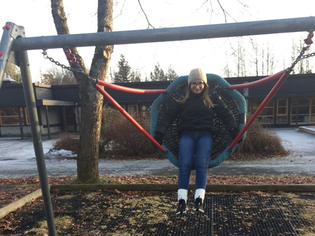 En jente som sitter i en huske