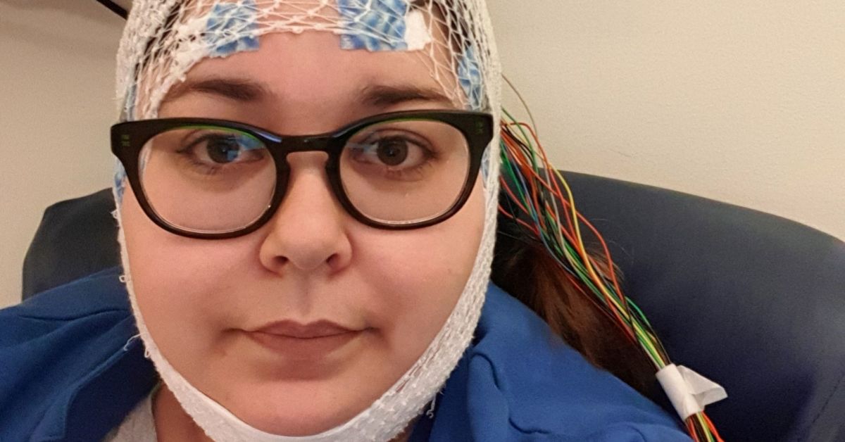Portrett av ung dame med nettingstrømpe og elektroder på hodet fordi hun gjennomfører telemetriundersøkelse